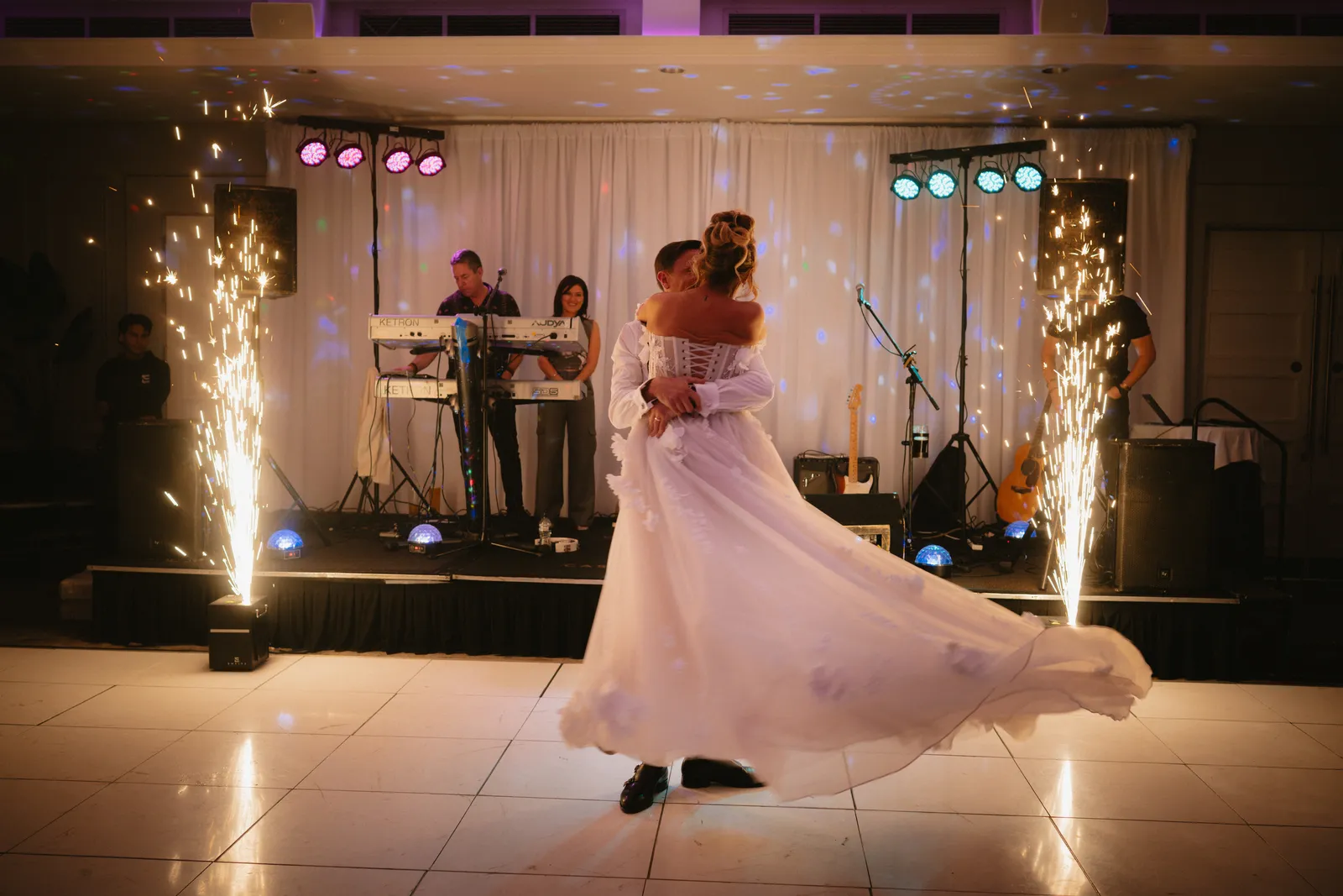 Tara turns on the dance floor beside Karl, with stage lights behind them.