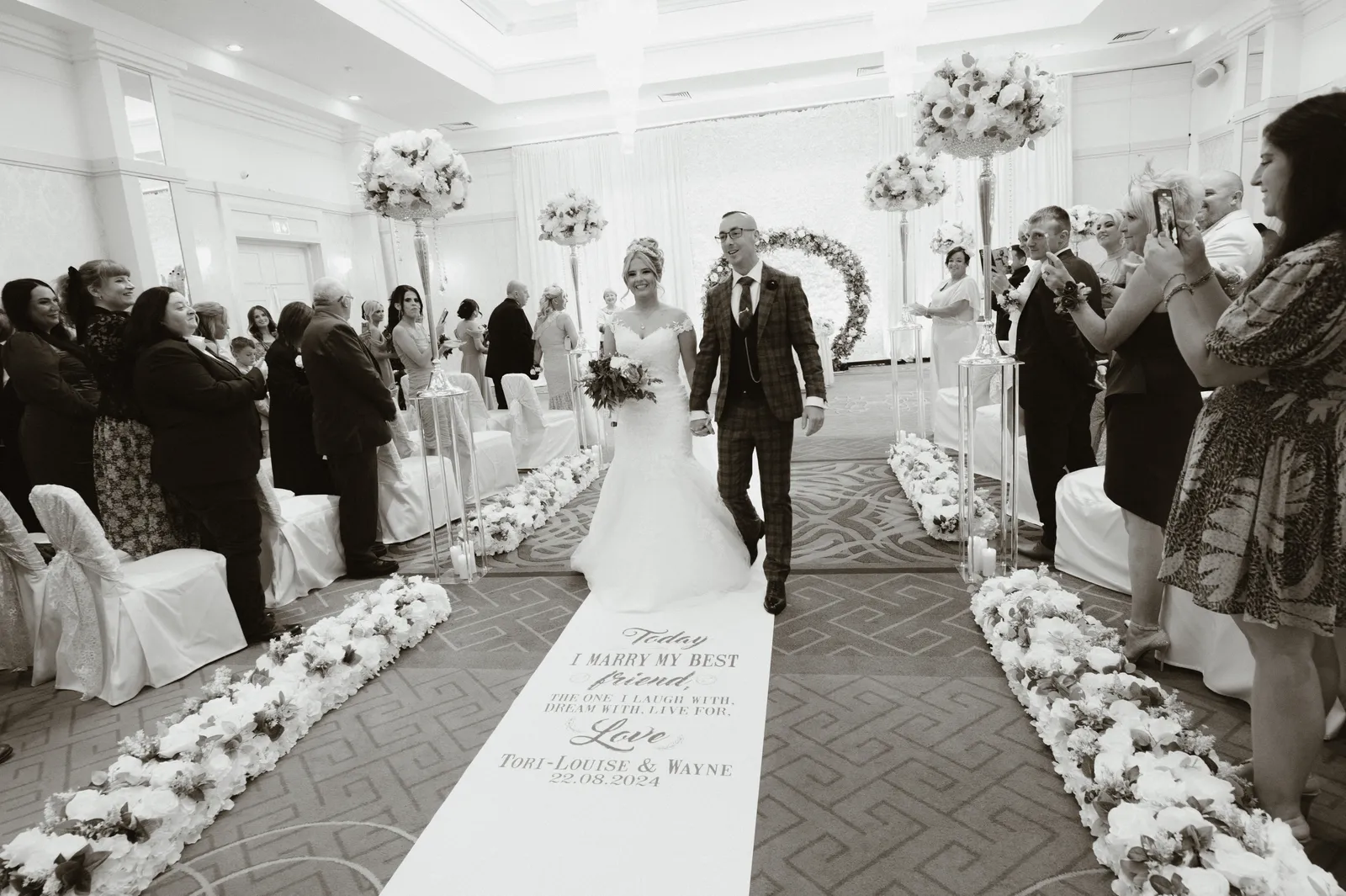 The couple leave down the ceremony aisle