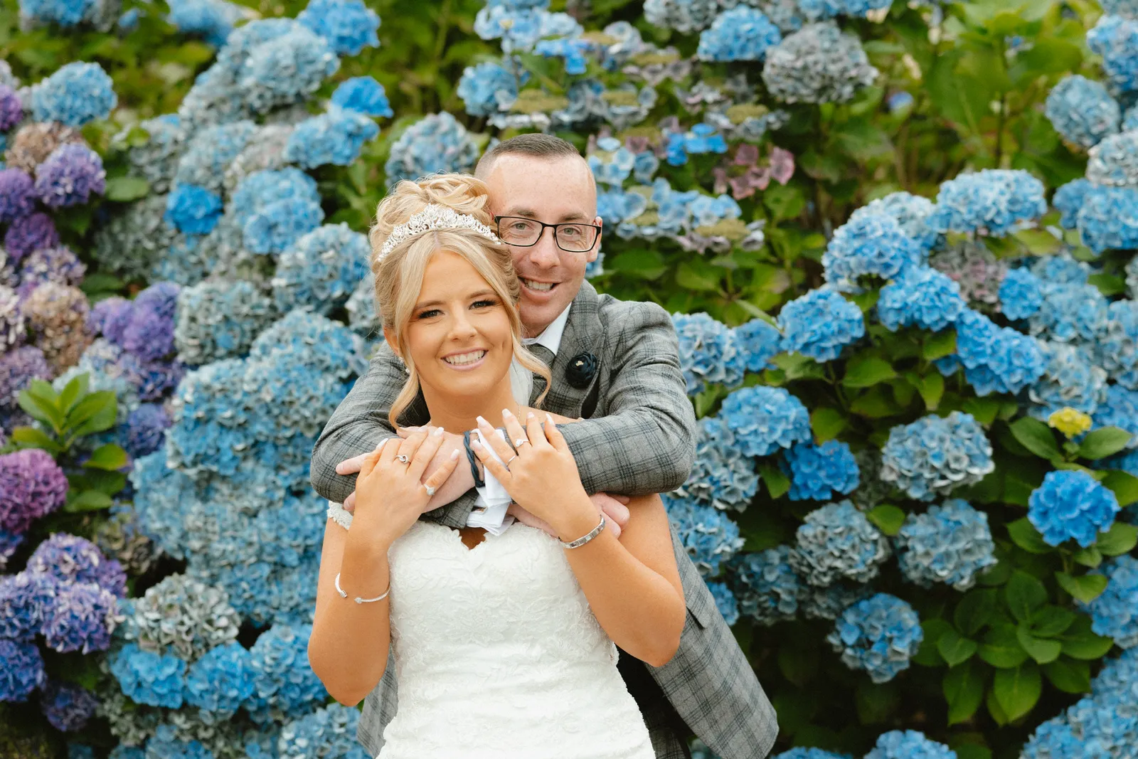 Tori and Wayne beside blue hydrangeas