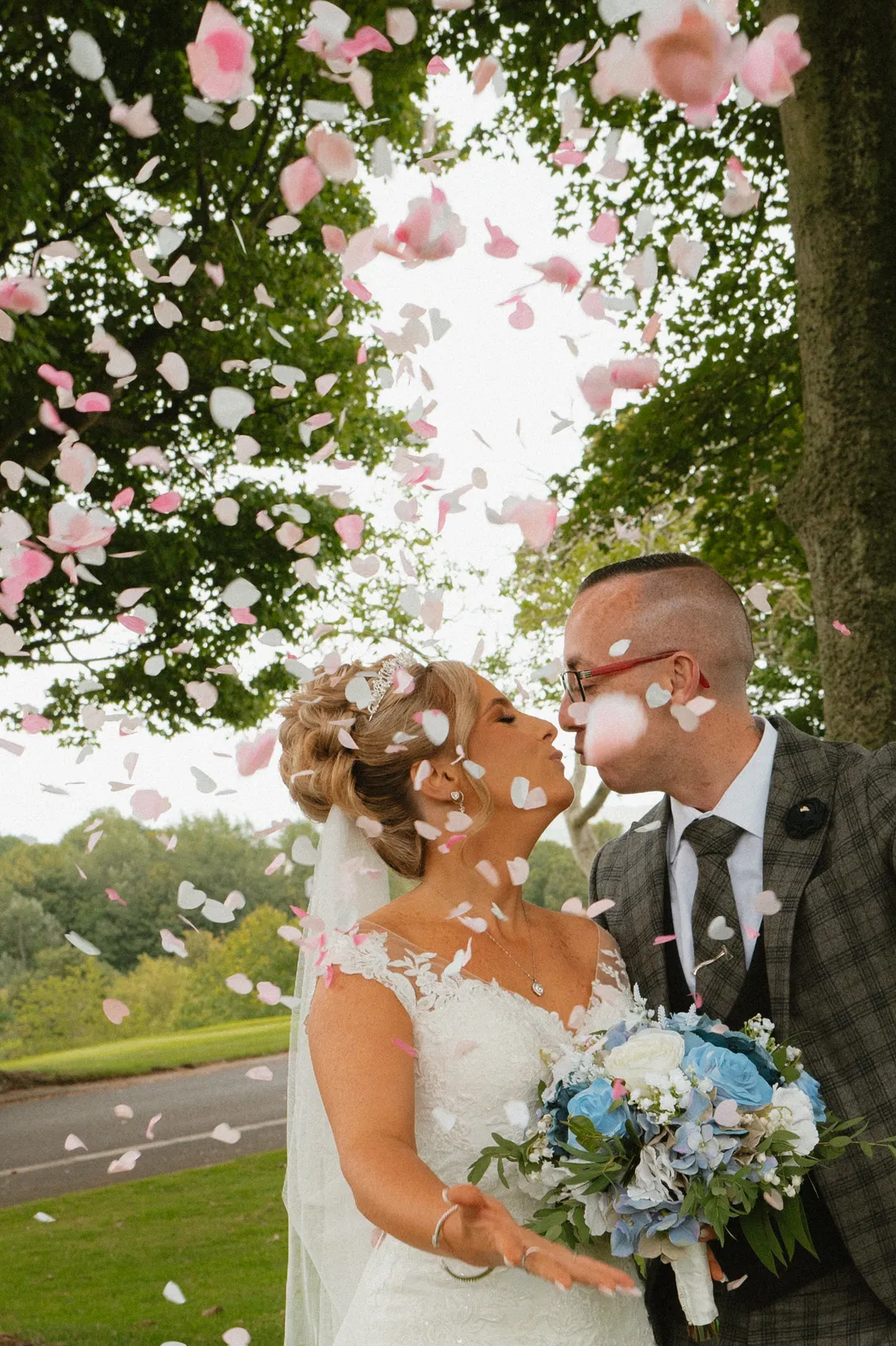 The couple beneath pink garden flowers