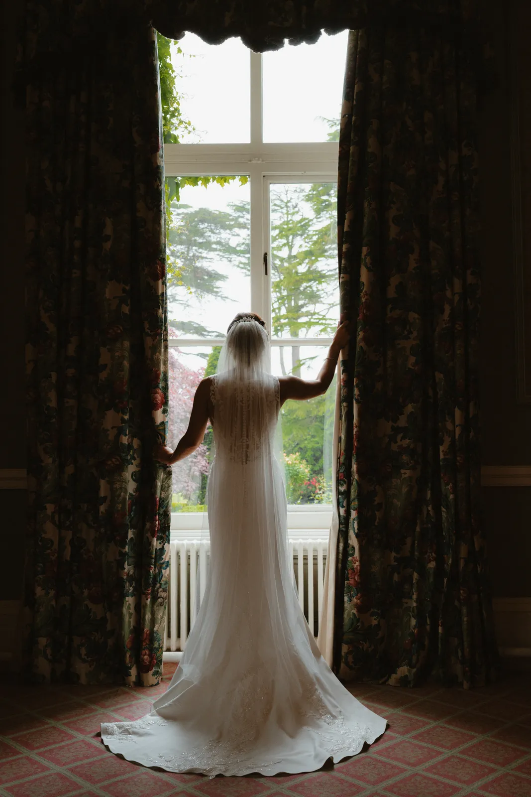 Vicky silhouetted at a tall window