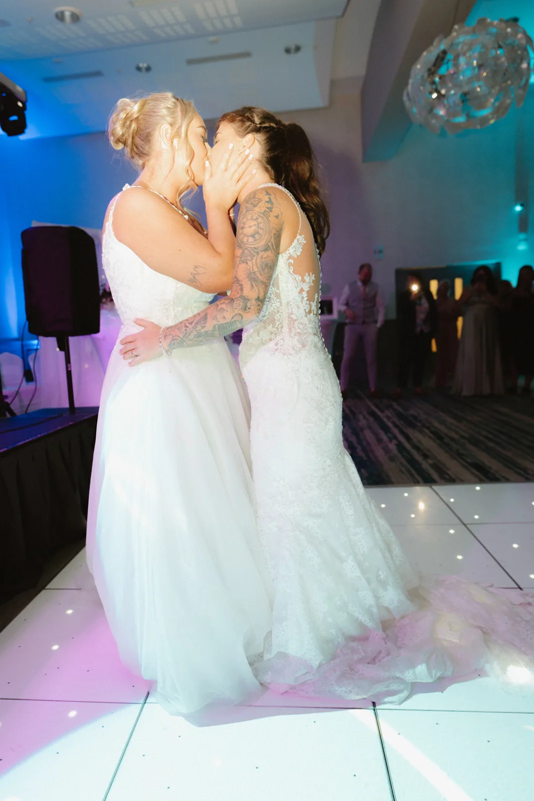 The couple dancing beneath coloured lights
