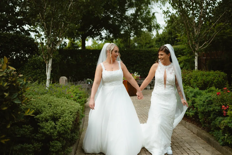Zoe and Siobhra walking hand in hand in the garden